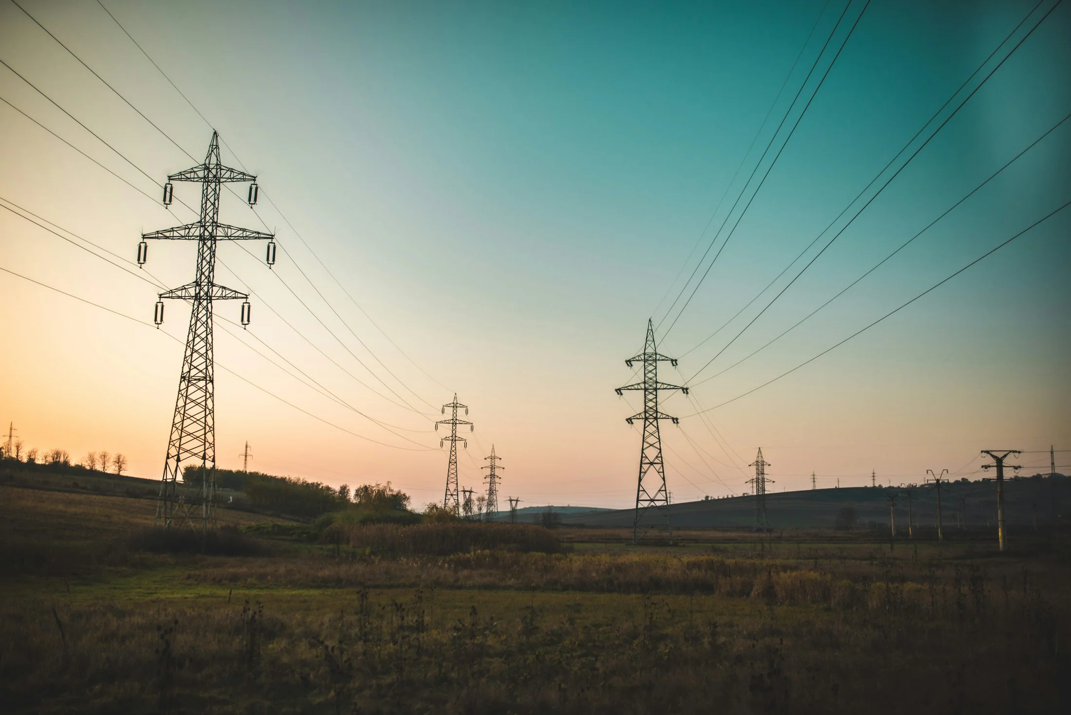 Stromtrasse in einer weiten Landschaft bei Abendlicht – Symbolbild